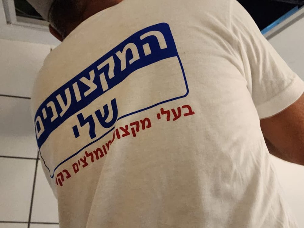 אינסטלטור של המקצוענים שלי בודק קו דרך פתח ביקורת בתקרה בבניין