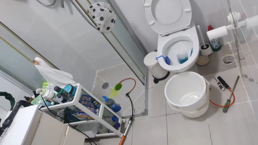 בדיקת צנרת בחדר שירותים עם ציוד בדיקה וכלי עבודה