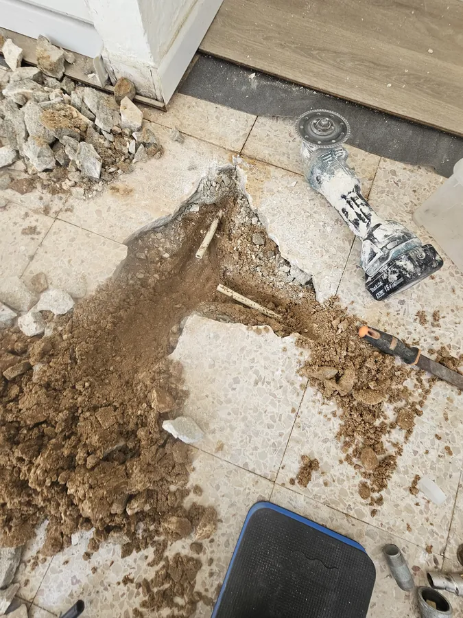 חציבת ריצוף ממוקדת כדי להגיע לצינור שהתפוצץ