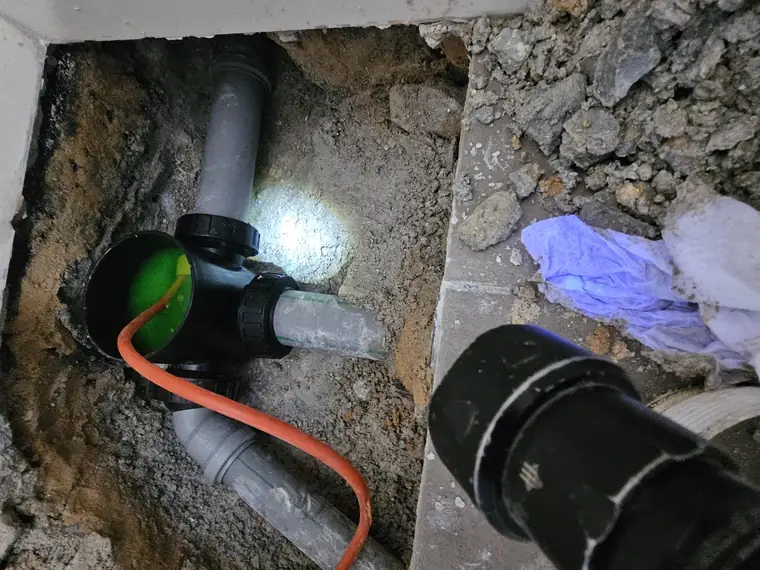 איתור נזילה בעזרת חומר ניגוד ירוק בשוחת ביוב, עם תאורה נקודתית
