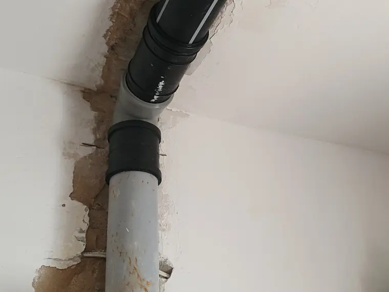 קו ניקוז אנכי חשוף במעבר קיר, לפני סגירה — נקודת גישה נוספת לצילום