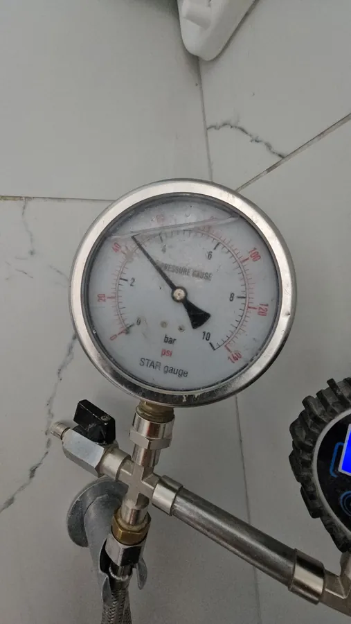 מד לחץ מים אנלוגי מחובר לנקודת מים בזמן בדיקת לחץ