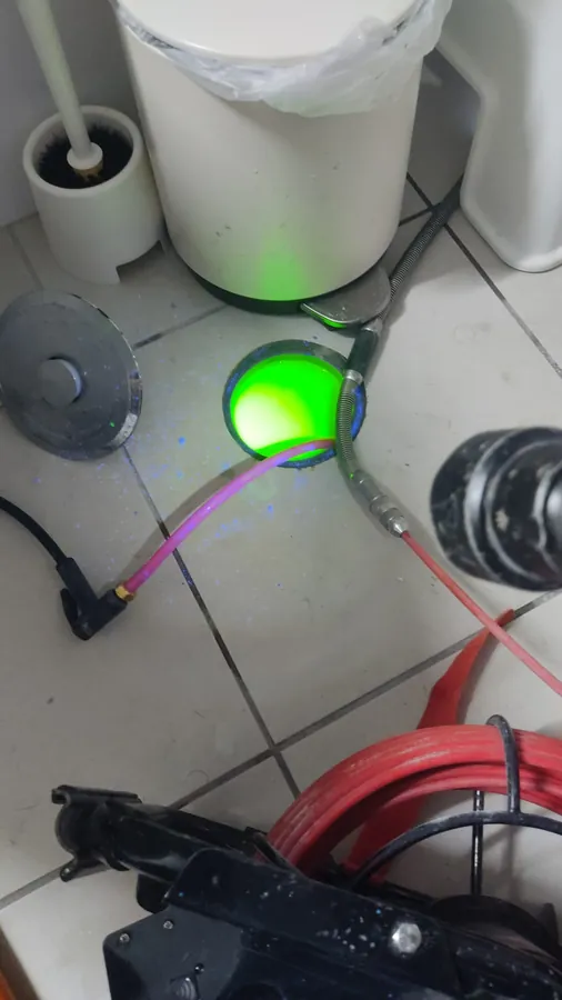 מחסום רצפה עם צבע פלואורסצנטי ירוק וכבל מצלמת צנרת בתוכו