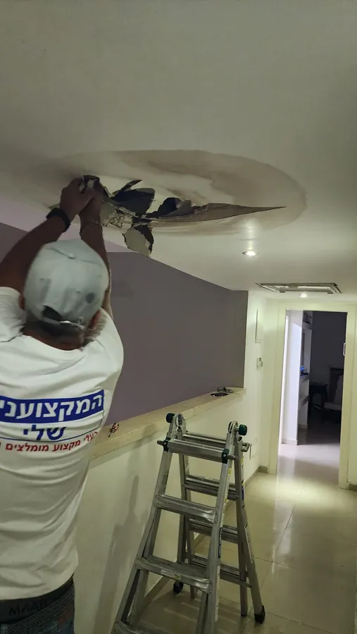 פתיחת תקרת גבס עם כתם רטיבות כדי לאתר את מקור הנזילה מהתקרה