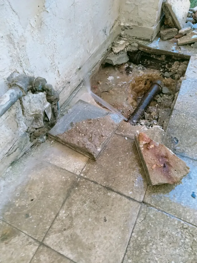 פיצוץ צינור מים מתחת לריצוף: סילון מים יוצא מהצינור אחרי פתיחת האריחים