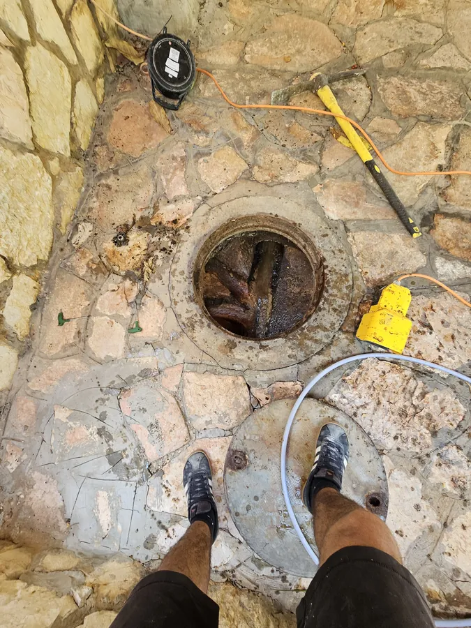 שוחת ביוב פתוחה ומלאה בשורשים ובשפכים לפני פתיחת הסתימה