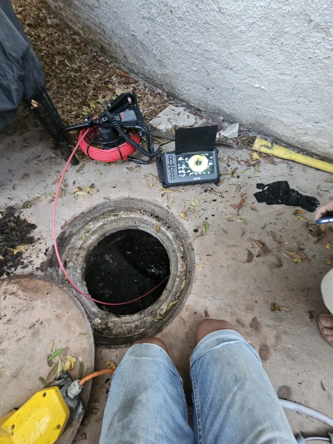 צילום קו ביוב מתוך שוחת ביקורת פתוחה בחצר, גליל מצלמה ומסך לידה