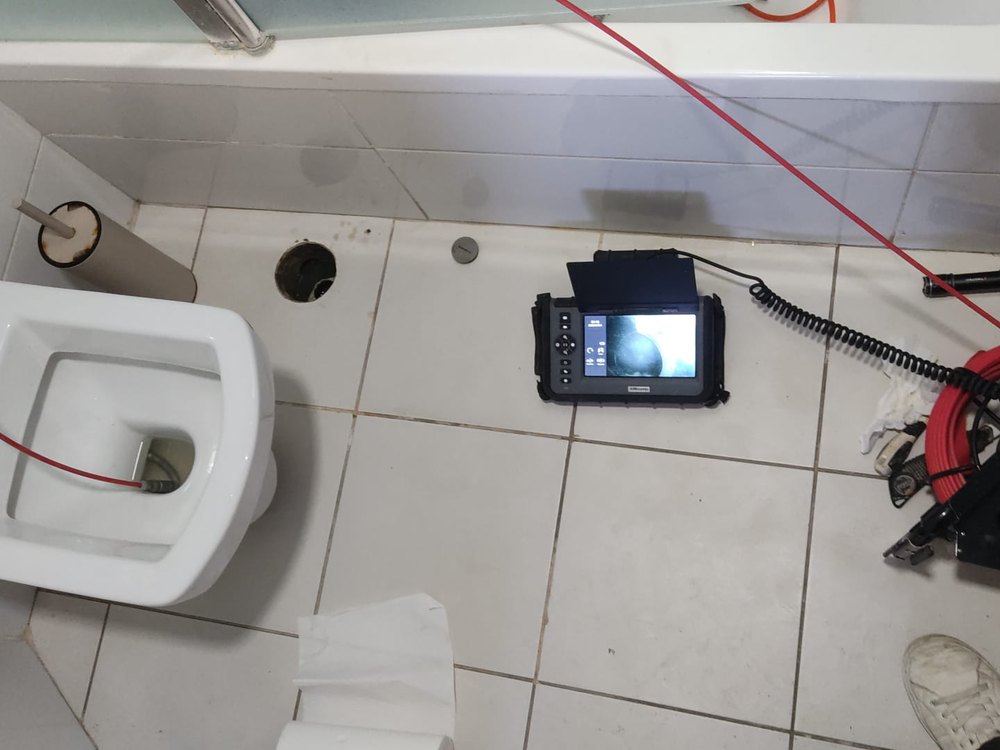 צילום קו דלוחין בחדר שירותים דרך פתח הניקוז שברצפה, עם מסך ומצלמה