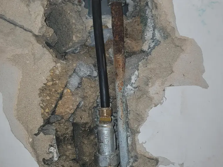 צינור ברזל בתוך קיר, עם רקורד ומעבר לצינור פוליאתילן שחור