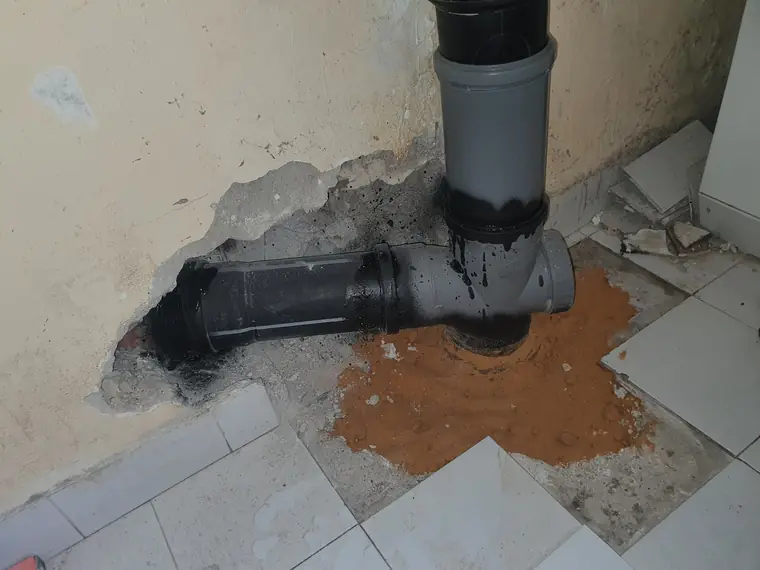 צינור ניקוז PP שחור ביציאה מהריצפה, בחיבור לקו הביוב הדירתי