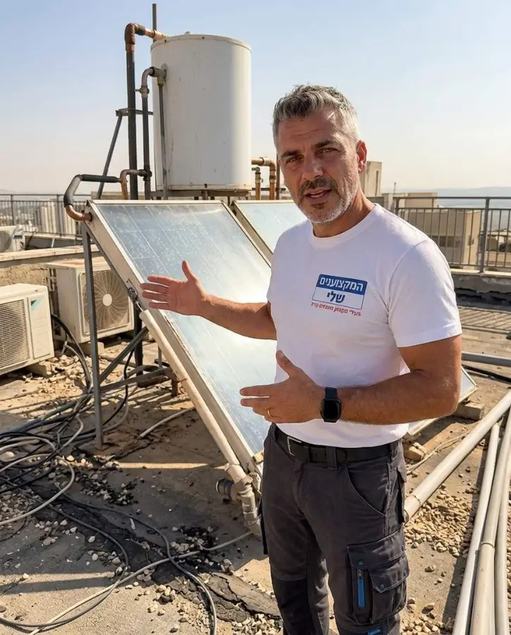 אינסטלטור מסביר על קולטי השמש והדוד על גג הבניין