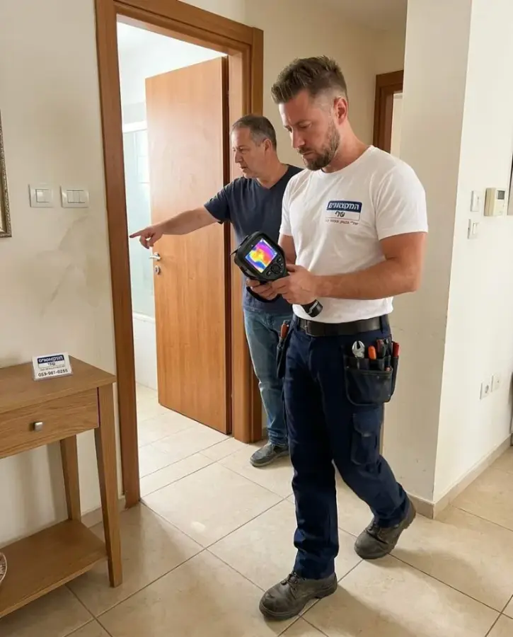 בעל הבית מראה את האזור החשוד בזמן איתור נזילה