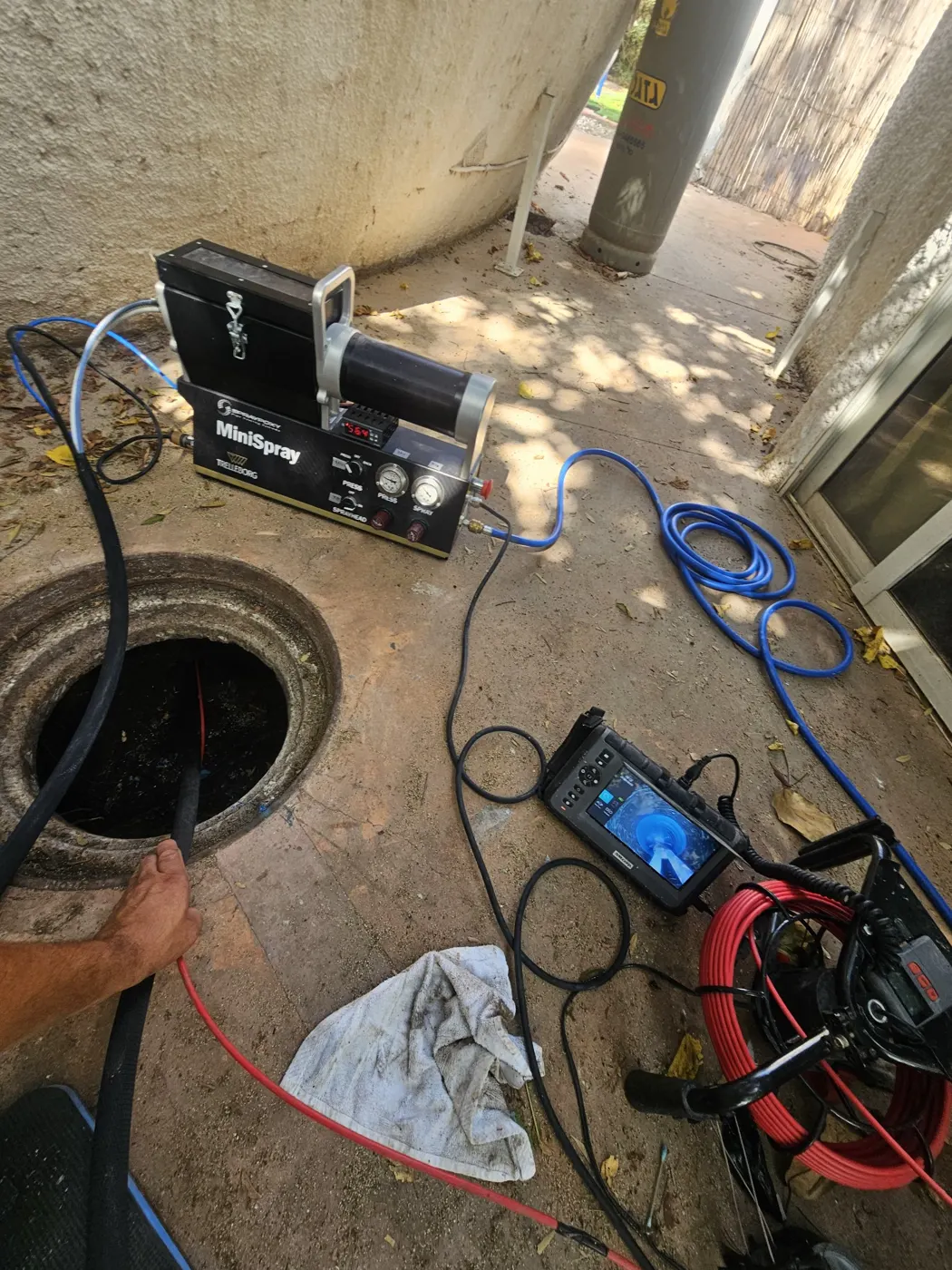 מכונת התזת אפוקסי מחוברת וצינור ההתזה נכנס לשוחה
