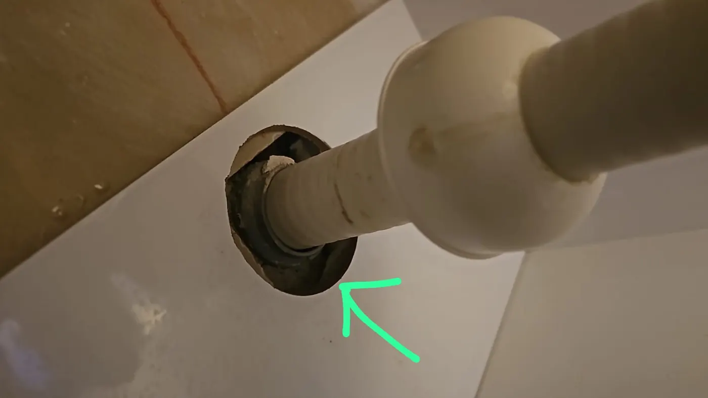 מרווח פתוח סביב צינור ניקוז בקיר, מסומן בחץ